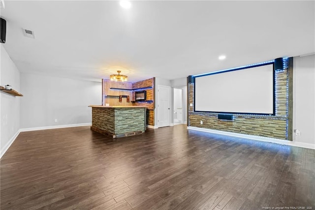 home theater with baseboards, dark wood-style flooring, and bar