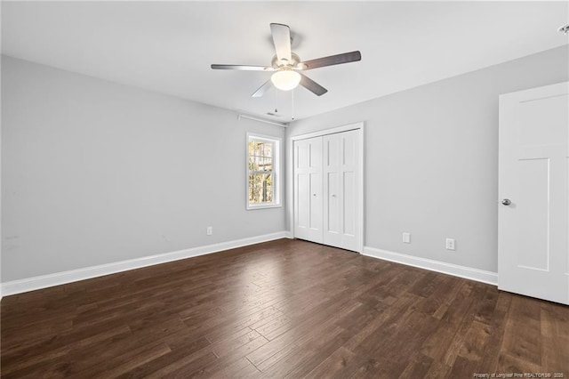 unfurnished bedroom featuring dark wood-style floors, baseboards, a closet, and ceiling fan