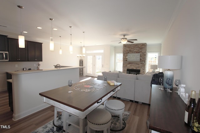 dining area featuring ornamental molding, healthy amount of natural light, dark wood-type flooring, a ceiling fan, and recessed lighting