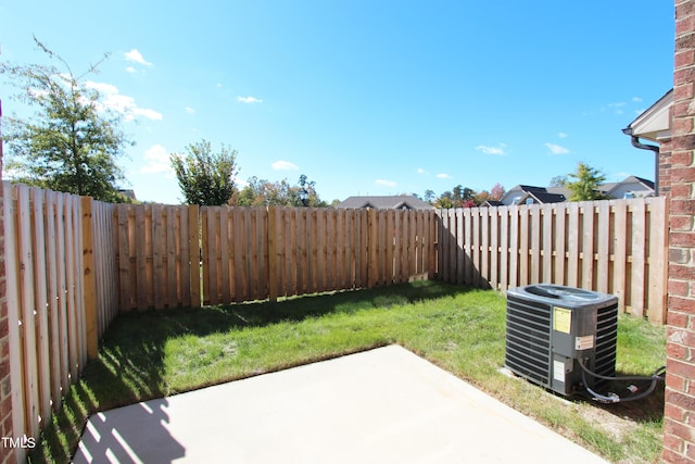 view of yard with central air condition unit and a patio area