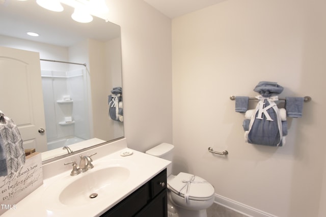 bathroom featuring toilet, vanity, and baseboards