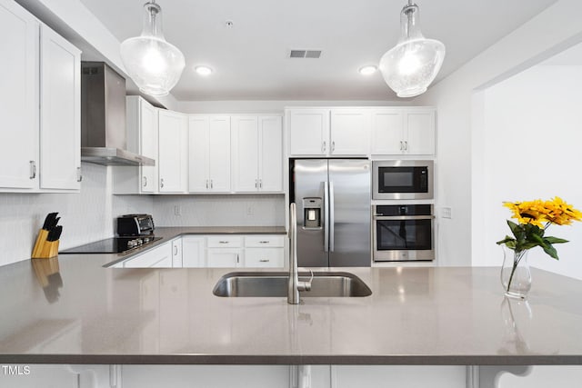 421 Wait Ave Unit 100, Wake Forest, NC 27587 - kitchen with appliances with stainless steel finishes, wall chimney range hood, a sink, white cabinets, and backsplash