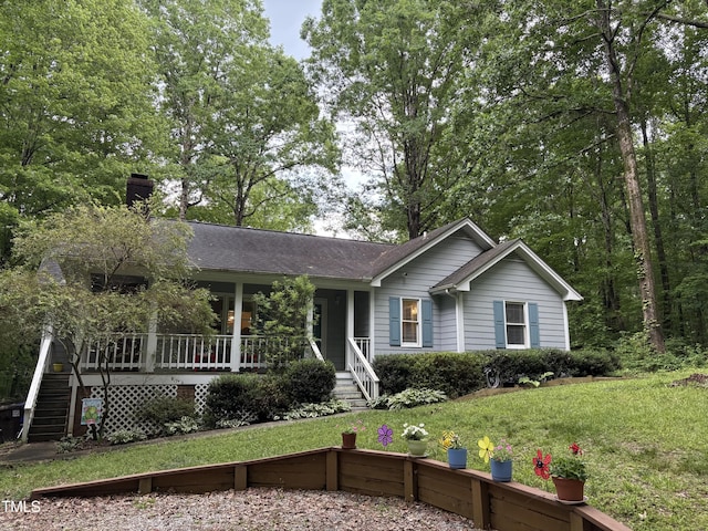 single story home with covered porch, a front yard, a chimney, and stairs