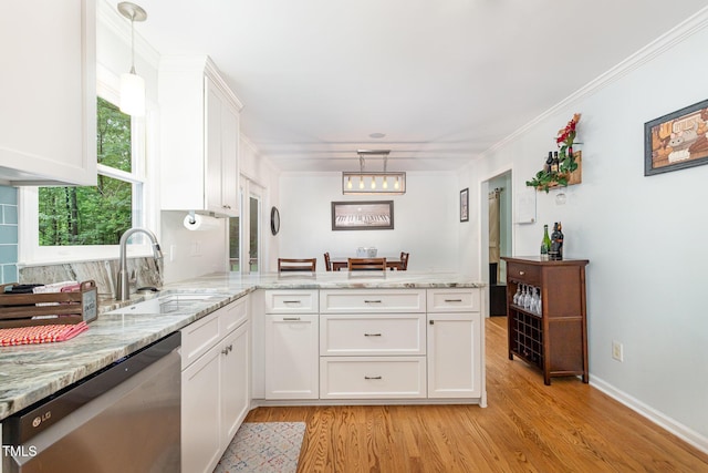 kitchen with dishwasher, a sink, a peninsula, white cabinets, and light wood finished floors