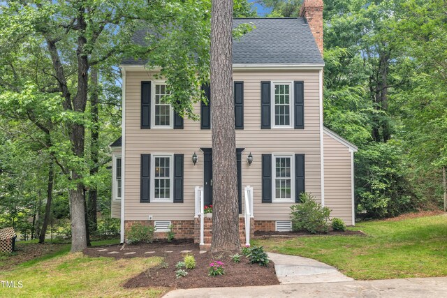 608 Cross Timbers Dr, Durham, NC 27713 - colonial house featuring a chimney, a front lawn, and roof with shingles