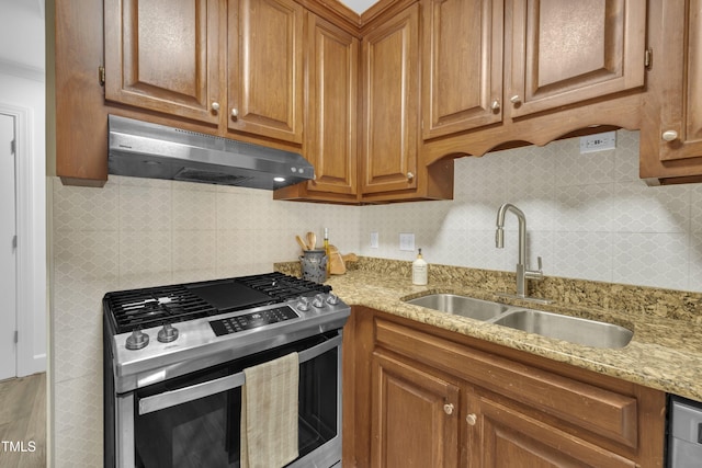608 Cross Timbers Dr, Durham, NC 27713 - kitchen with gas range, under cabinet range hood, a sink, brown cabinets, and backsplash