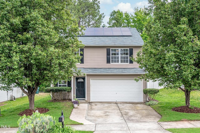 313 Weeping Willow Dr, Durham, NC 27704 - view of front facade featuring concrete driveway, an attached garage, roof mounted solar panels, and a front yard