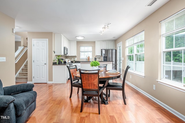 313 Weeping Willow Dr, Durham, NC 27704 - dining room with light wood-type flooring, stairway, and baseboards