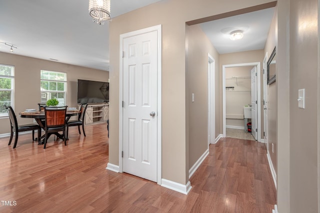 313 Weeping Willow Dr, Durham, NC 27704 - corridor with light wood-style floors, baseboards, and a chandelier