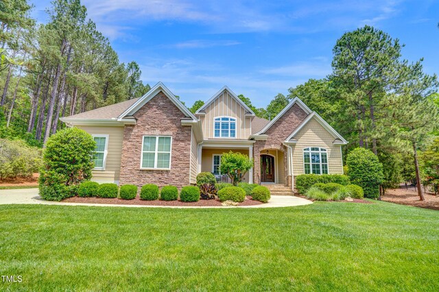 216 Colonial Ridge Dr, Pittsboro, NC 27312 - view of front facade with stone siding, a front lawn, and board and batten siding