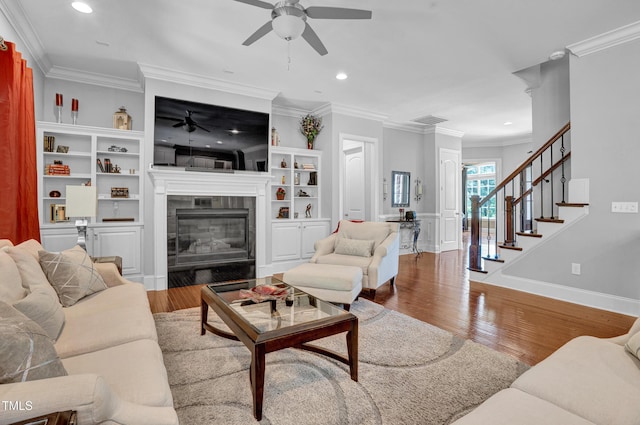 216 Colonial Ridge Dr, Pittsboro, NC 27312 - living room with a ceiling fan, a tile fireplace, wood finished floors, stairs, and ornamental molding