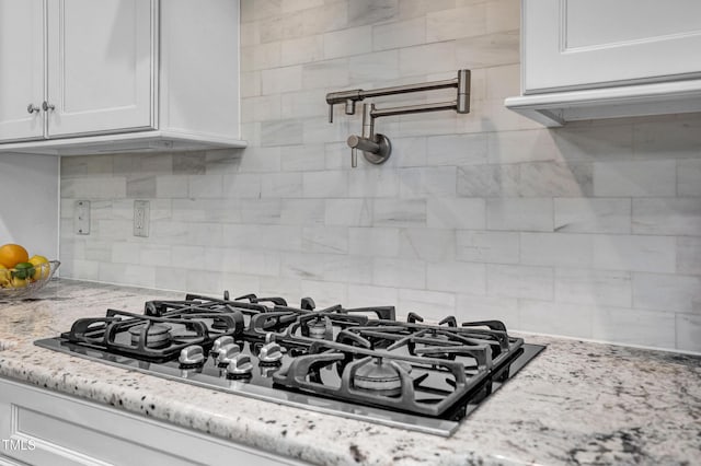 216 Colonial Ridge Dr, Pittsboro, NC 27312 - kitchen view of pot filler, black gas stovetop, tasteful backsplash, and white cabinets