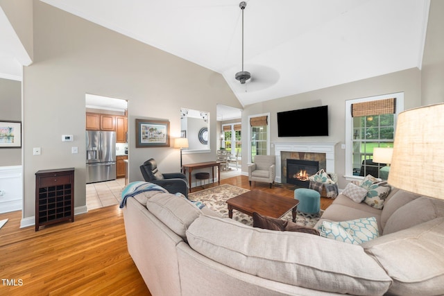 3916 Rustic Mill Dr, Apex, NC 27539 - living area featuring high vaulted ceiling, healthy amount of natural light, light wood-style flooring, a fireplace, and ceiling fan