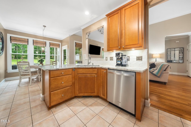 3916 Rustic Mill Dr, Apex, NC 27539 - kitchen featuring dishwasher, a sink, light stone counters, brown cabinetry, and decorative backsplash
