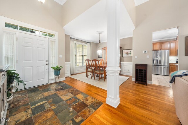 3916 Rustic Mill Dr, Apex, NC 27539 - entryway featuring ornamental molding, a wainscoted wall, a towering ceiling, and wood finished floors