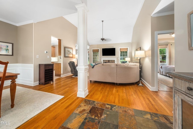 3916 Rustic Mill Dr, Apex, NC 27539 - living room featuring ornate columns, vaulted ceiling, a fireplace, ornamental molding, and wood finished floors