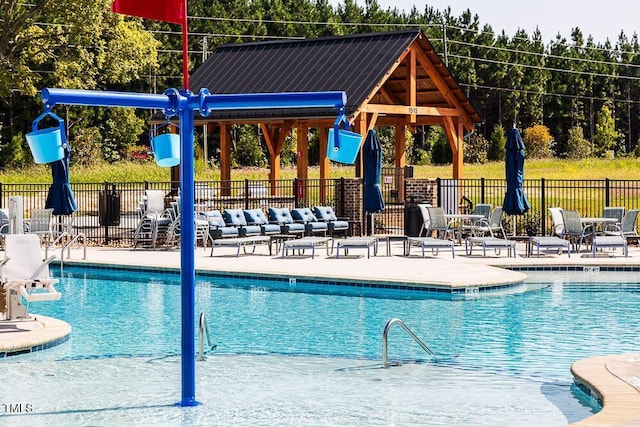 community pool with fence and a patio
