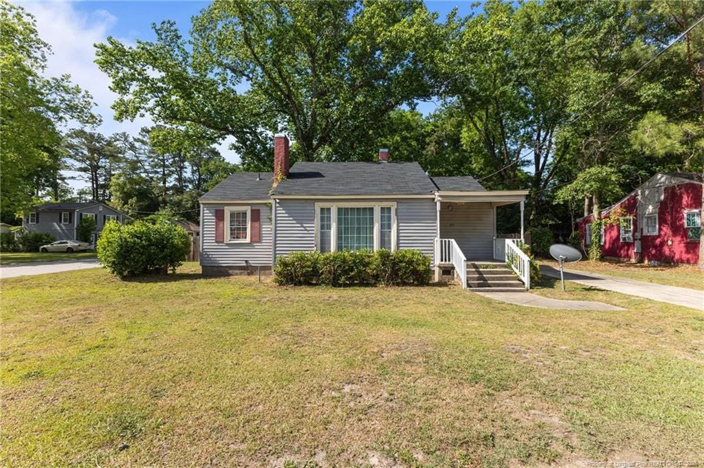 bungalow-style house with a front lawn and a chimney