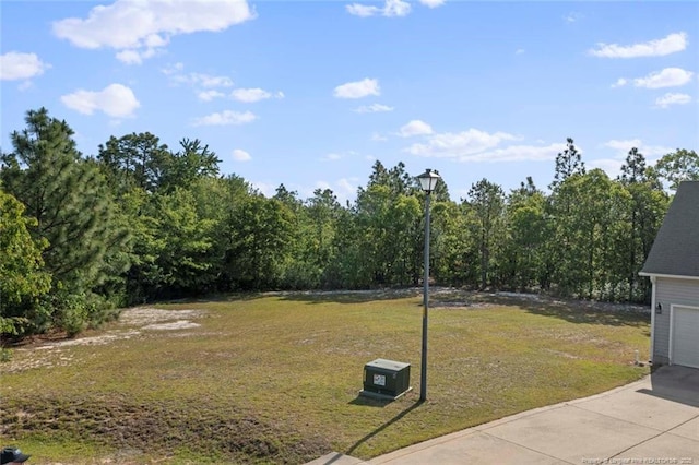 view of green lawn with a garage