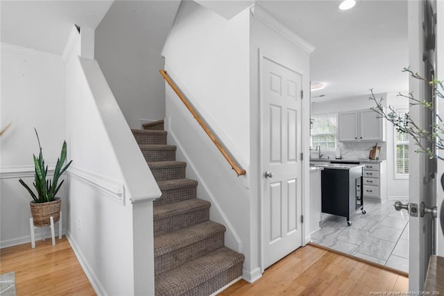 stairway featuring ornamental molding, wood finished floors, recessed lighting, and baseboards