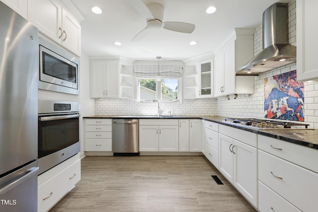 712 Beaver Dam Rd, Raleigh, NC 27607 - kitchen featuring appliances with stainless steel finishes, wall chimney range hood, open shelves, ceiling fan, and white cabinetry