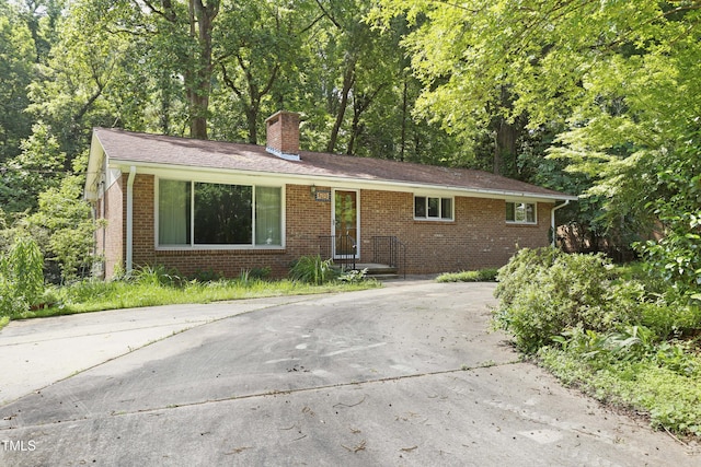 712 Beaver Dam Rd, Raleigh, NC 27607 - view of front facade featuring a chimney and brick siding