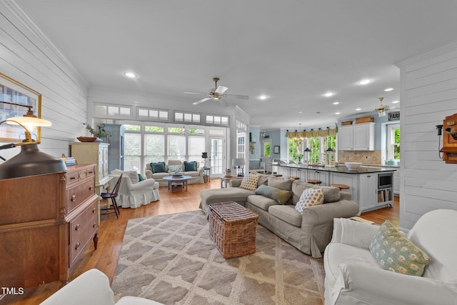 5308 Stableview Ct, Holly Springs, NC 27540 - living area featuring a ceiling fan, crown molding, wood walls, light wood-style flooring, and recessed lighting