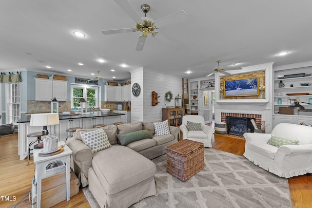 5308 Stableview Ct, Holly Springs, NC 27540 - living area with ceiling fan, light wood-style flooring, a brick fireplace, and recessed lighting