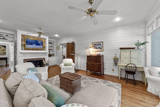 5308 Stableview Ct, Holly Springs, NC 27540 - living area featuring ceiling fan, a barn door, ornamental molding, recessed lighting, and a brick fireplace