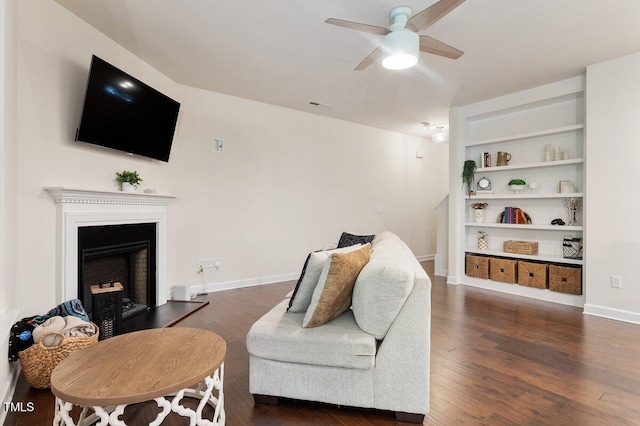 270 Wembley Dr, Clayton, NC 27527 - living room featuring a ceiling fan, wood finished floors, a fireplace with raised hearth, and baseboards