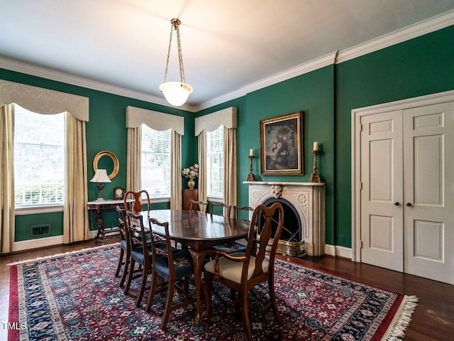 dining area featuring wood finished floors, crown molding, and baseboards