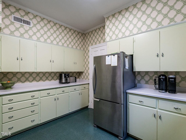 kitchen with freestanding refrigerator, ornamental molding, light countertops, backsplash, and wallpapered walls