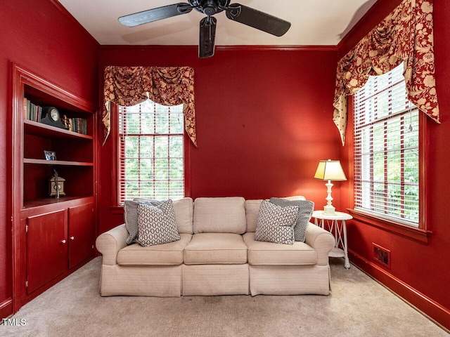living room featuring a ceiling fan, carpet, and ornamental molding