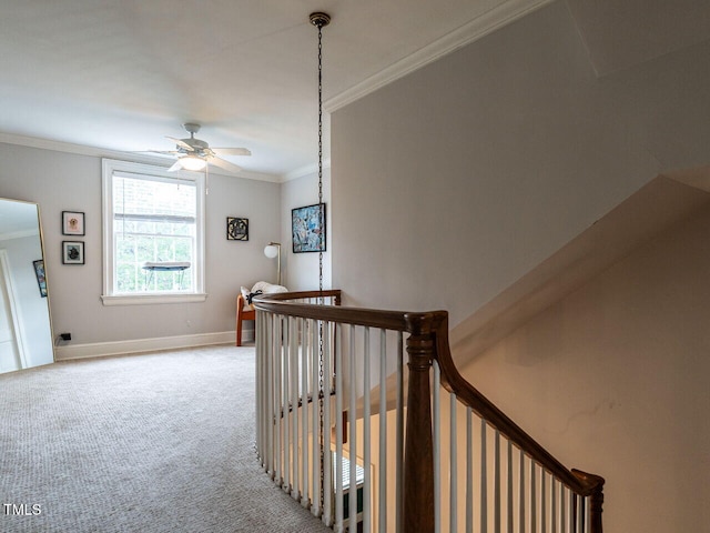 hallway with ornamental molding, an upstairs landing, carpet floors, and baseboards
