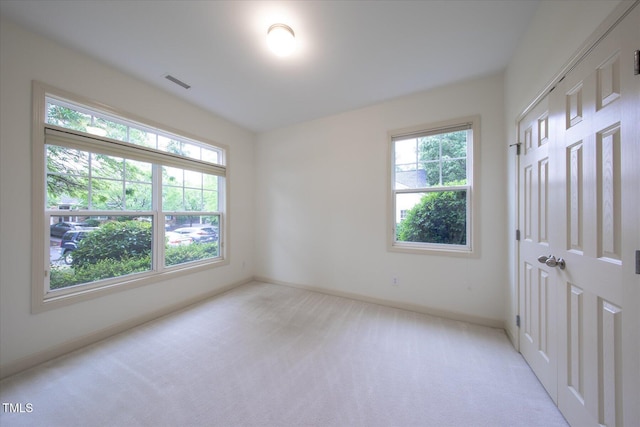 unfurnished bedroom featuring light carpet, baseboards, and a closet