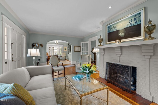1015 Watts St, Durham, NC 27701 - living room featuring arched walkways, wood finished floors, crown molding, a brick fireplace, and recessed lighting