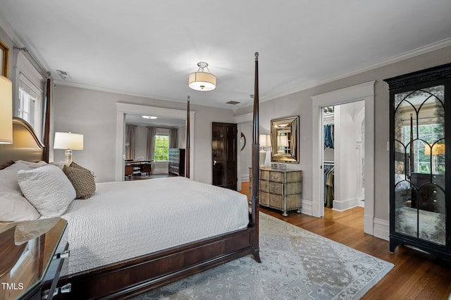 1015 Watts St, Durham, NC 27701 - bedroom featuring a spacious closet, wood finished floors, ornamental molding, baseboards, and a closet