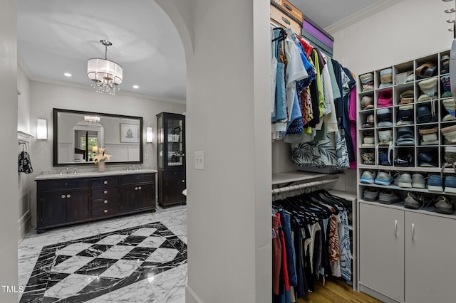 1015 Watts St, Durham, NC 27701 - spacious closet with arched walkways, a chandelier, a sink, and light marble finish flooring