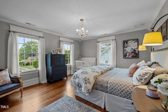 1015 Watts St, Durham, NC 27701 - bedroom featuring multiple windows, wood finished floors, a chandelier, ornamental molding, and baseboards