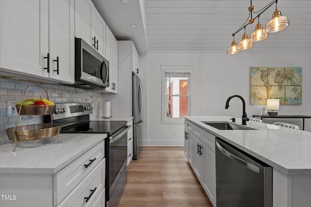 1015 Watts St, Durham, NC 27701 - kitchen with stainless steel appliances, a sink, a center island with sink, tasteful backsplash, and white cabinetry
