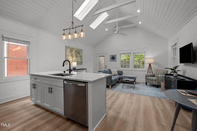 1015 Watts St, Durham, NC 27701 - kitchen with stainless steel dishwasher, a sink, open floor plan, a skylight, and light countertops