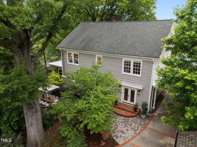 1015 Watts St, Durham, NC 27701 - view of front facade featuring french doors, a chimney, and a shingled roof