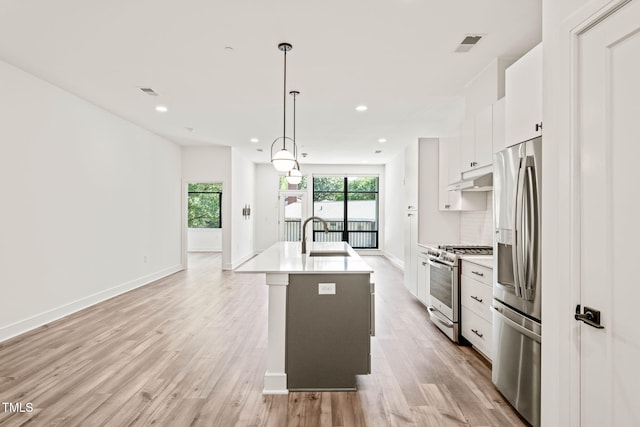 615 Daniels St Unit 215, Raleigh, NC 27605 - kitchen with appliances with stainless steel finishes, white cabinets, a sink, an island with sink, and light countertops
