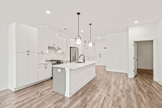 615 Daniels St Unit 215, Raleigh, NC 27605 - kitchen with appliances with stainless steel finishes, a sink, under cabinet range hood, light wood-style floors, and recessed lighting