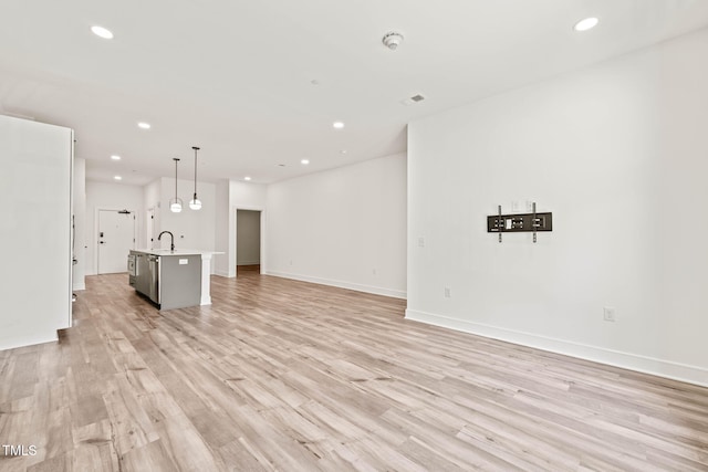 615 Daniels St Unit 215, Raleigh, NC 27605 - unfurnished living room with a sink, recessed lighting, light wood-style flooring, and baseboards