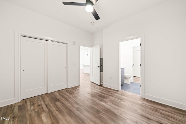 615 Daniels St Unit 215, Raleigh, NC 27605 - unfurnished bedroom with wood finished floors, a closet, ensuite bath, baseboards, and ceiling fan