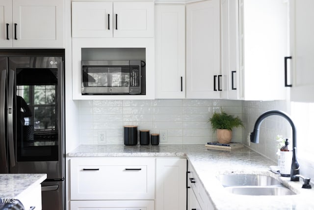 kitchen with stainless steel appliances, a sink, and white cabinets