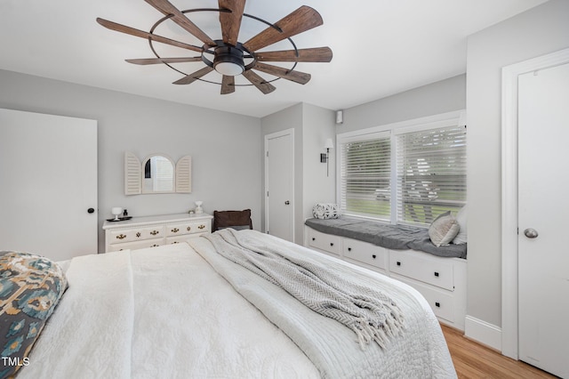 bedroom with light wood-type flooring, a ceiling fan, and baseboards