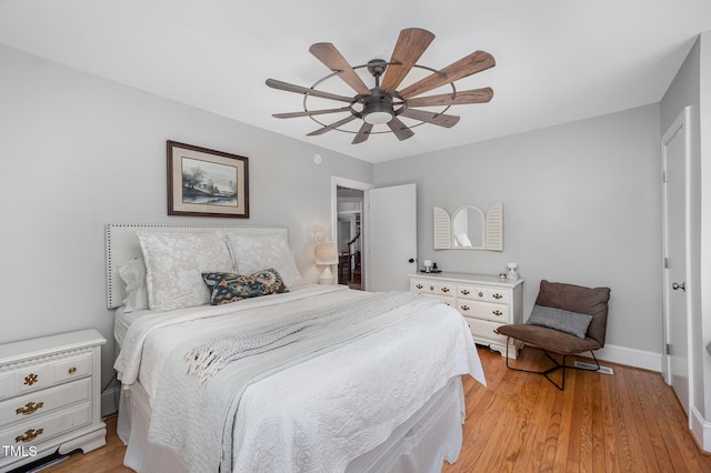 bedroom featuring baseboards, light wood-type flooring, and ceiling fan