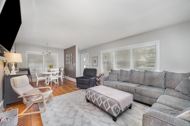 living area with wood finished floors, a chandelier, and baseboards